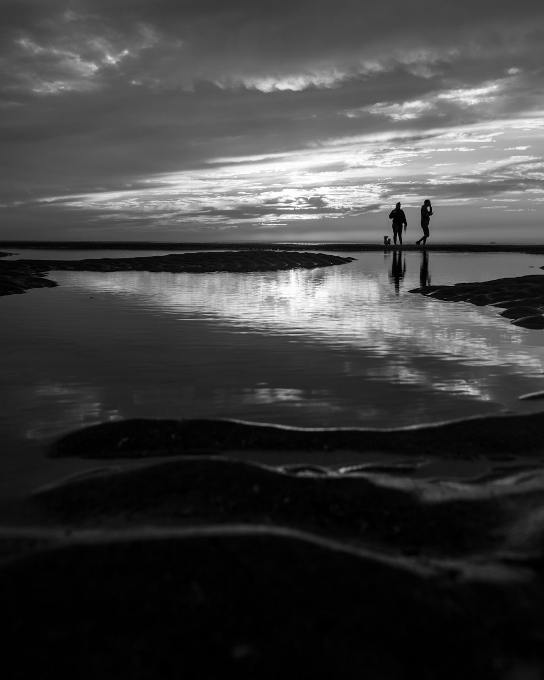 silhouette of person standing on seashore during daytime