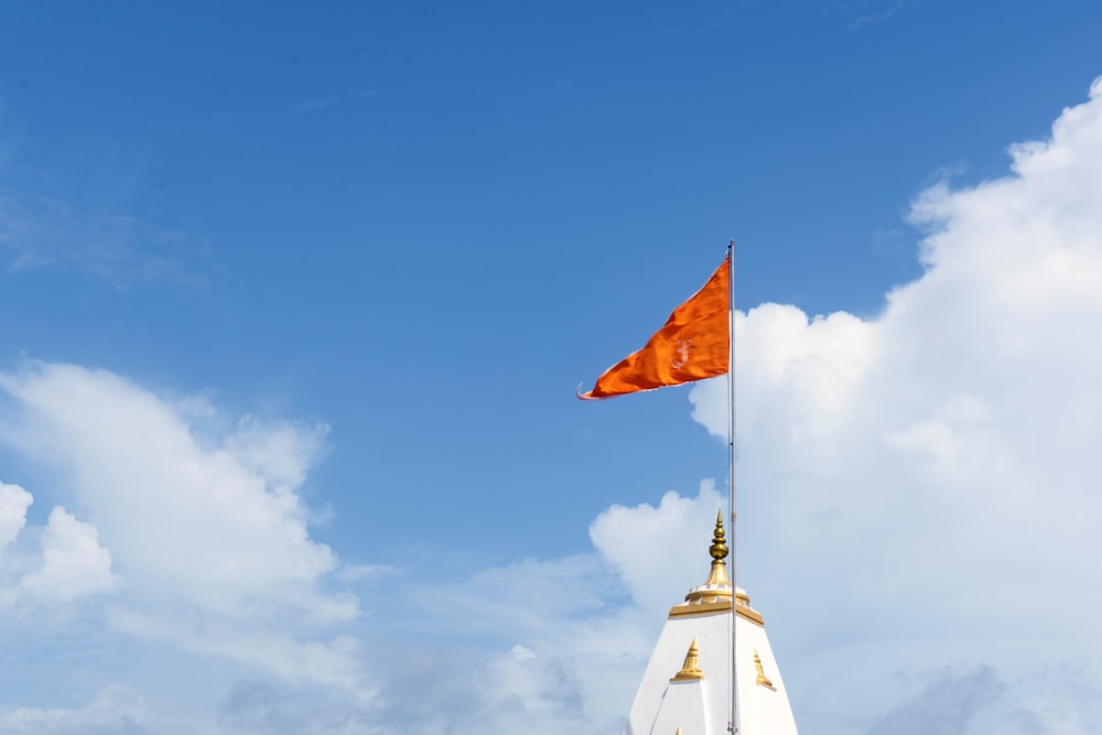 bandeira amarela e branca sob o céu azul durante o dia