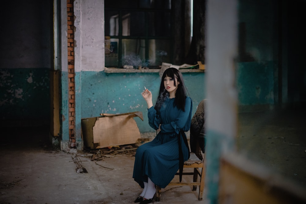 woman in blue dress sitting on chair