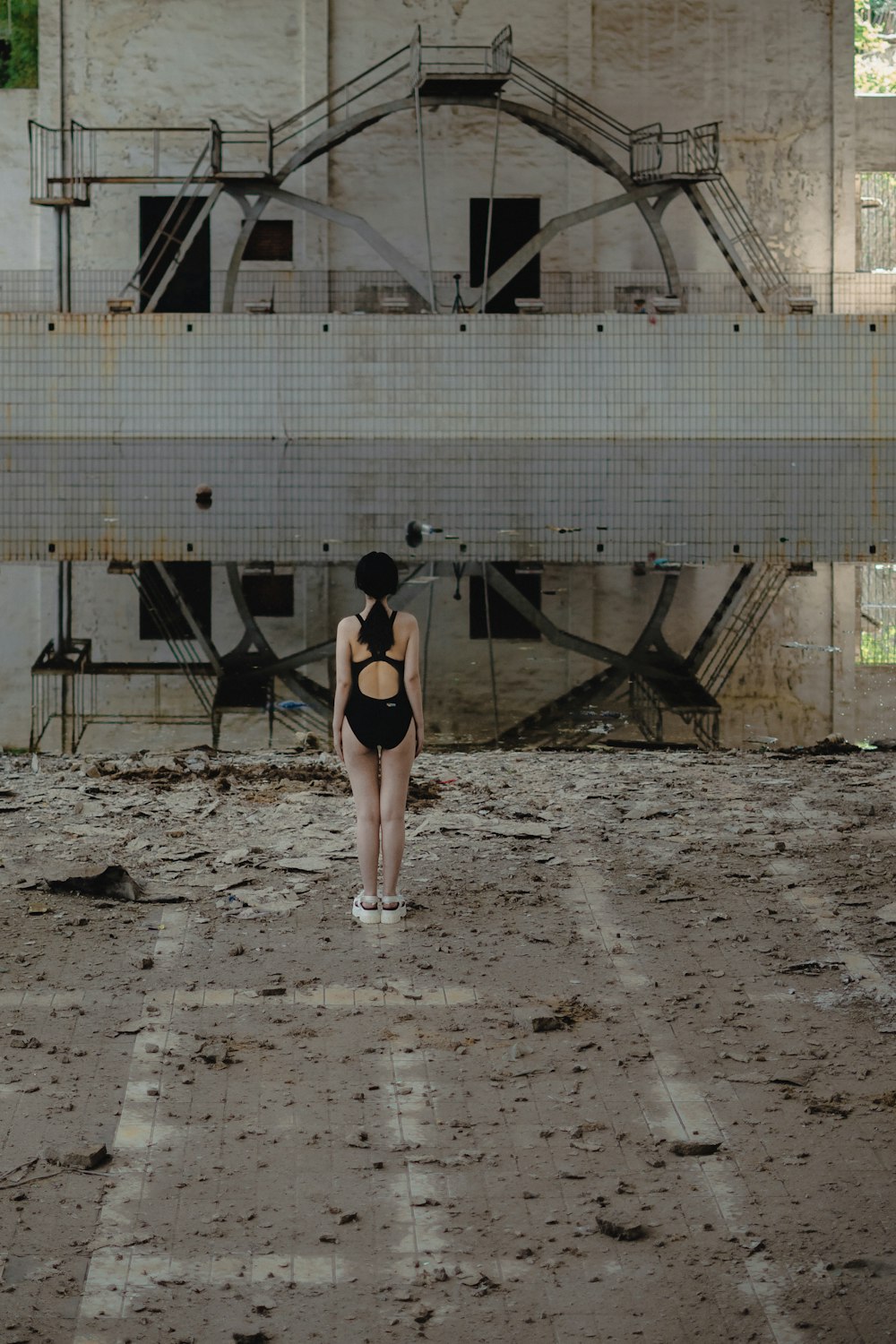 woman in black sports bra and black shorts standing on brown sand during daytime