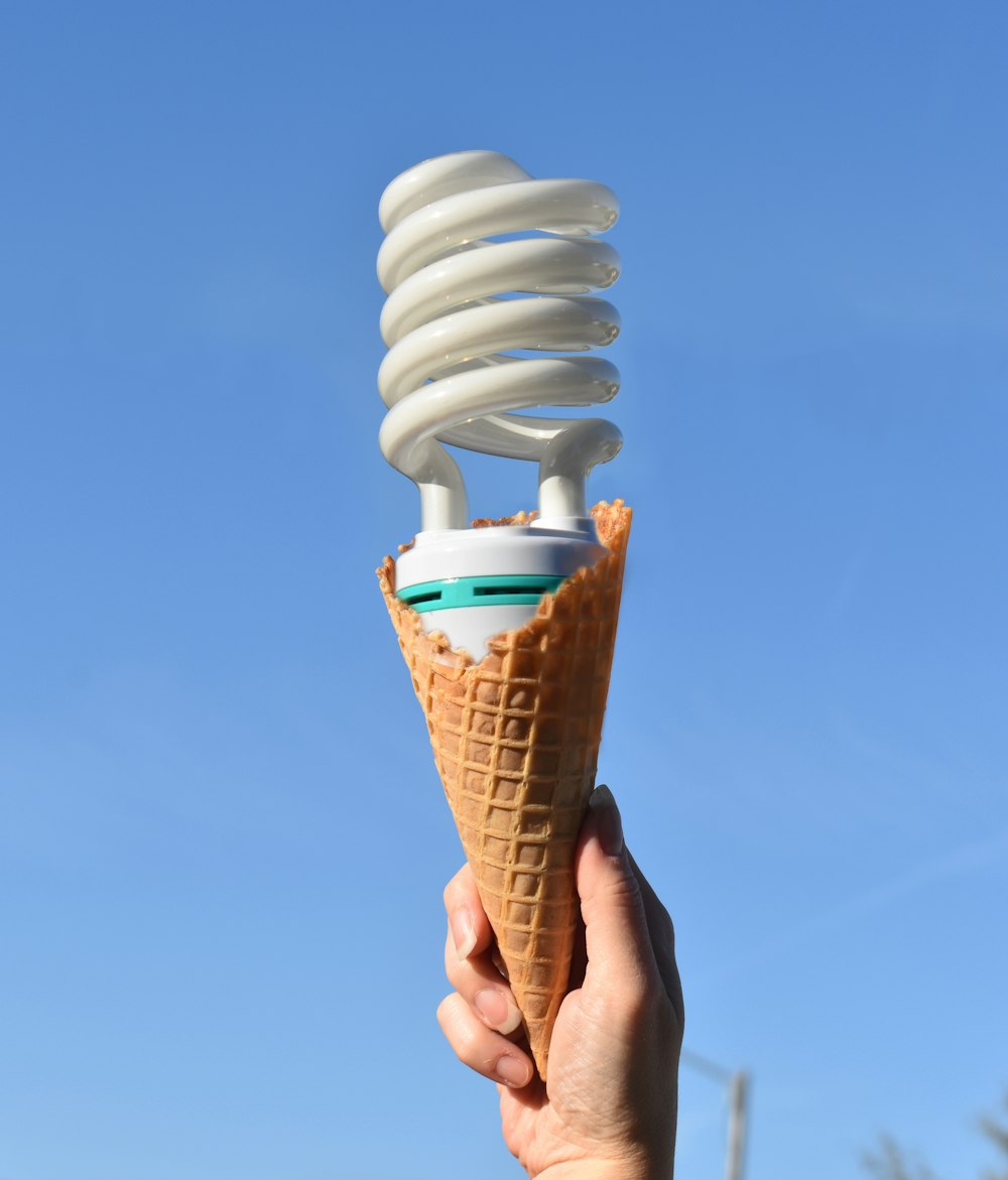 Persona sosteniendo un cono de helado blanco