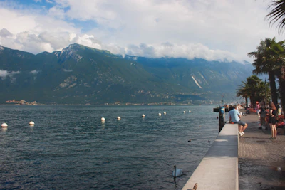 people on dock near mountain during daytime