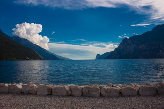 body of water near mountain under blue sky during daytime in Lake Garda Italy