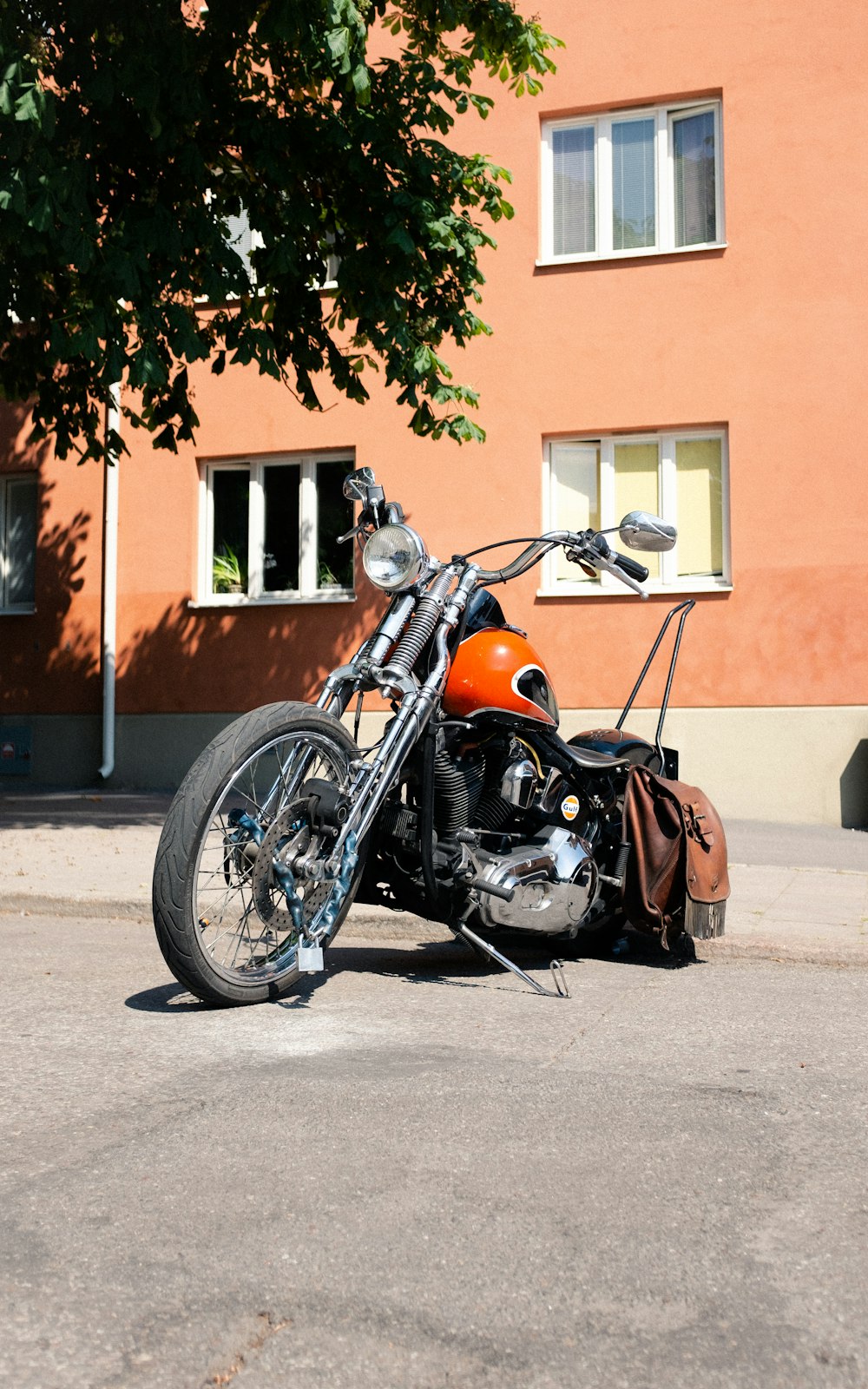 orange and black motorcycle parked on gray concrete road during daytime