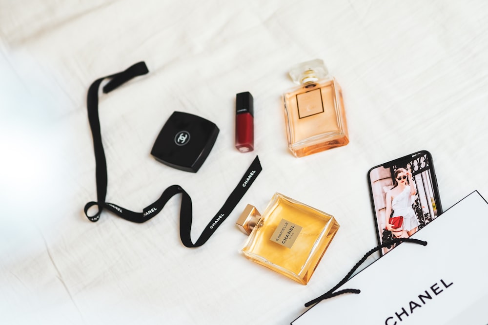 black framed eyeglasses beside brown and black perfume bottle