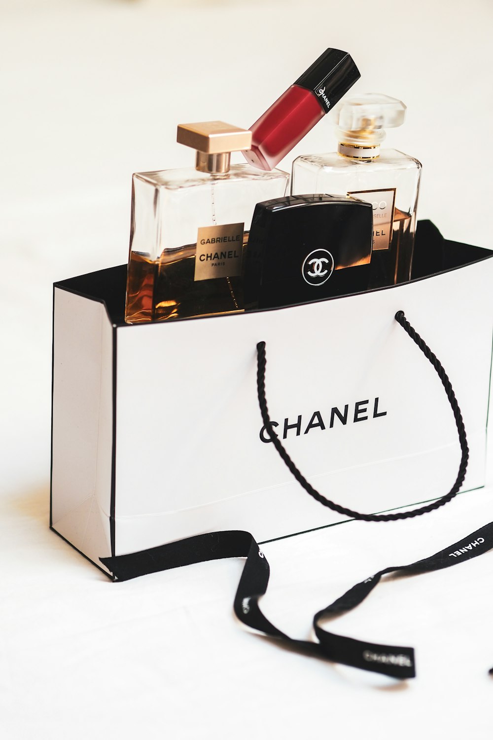 A chanel bag with a bottle of perfume in it photo – Free