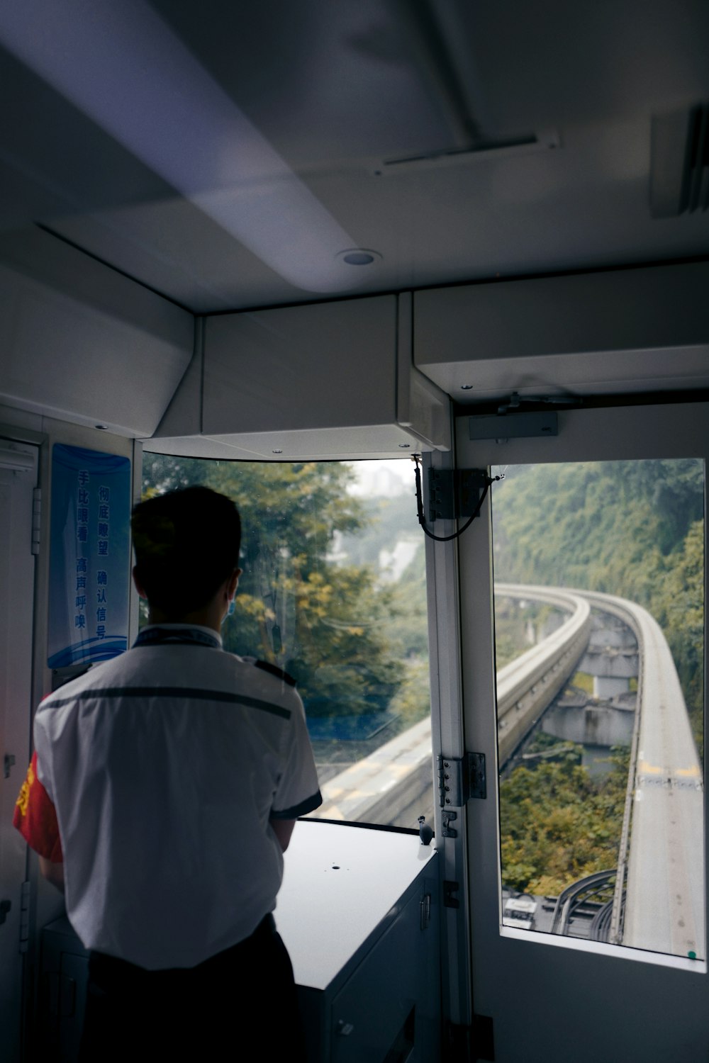 man in white dress shirt standing near window