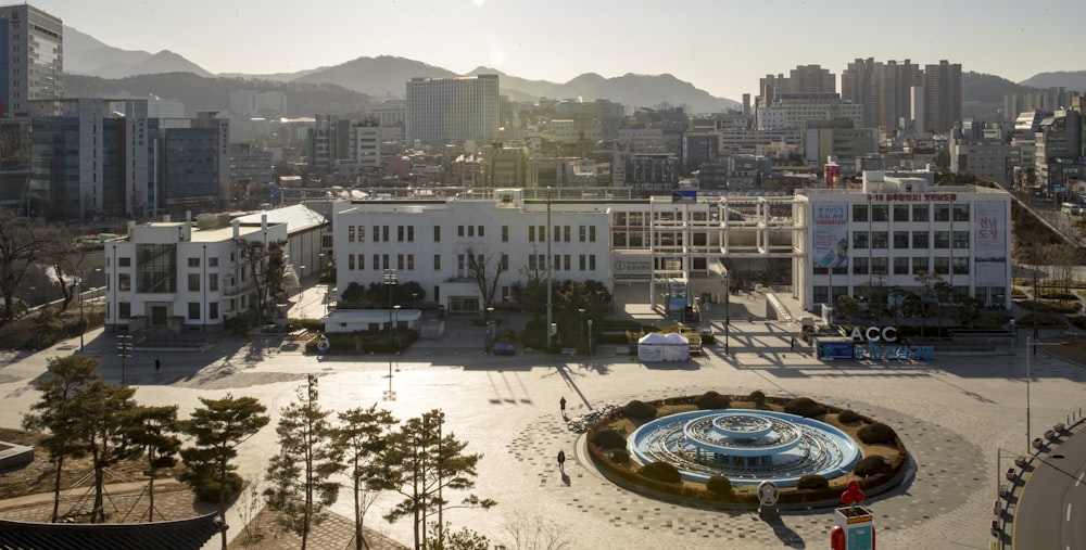 Fontana rotonda bianca e blu nel mezzo degli edifici della città durante il giorno