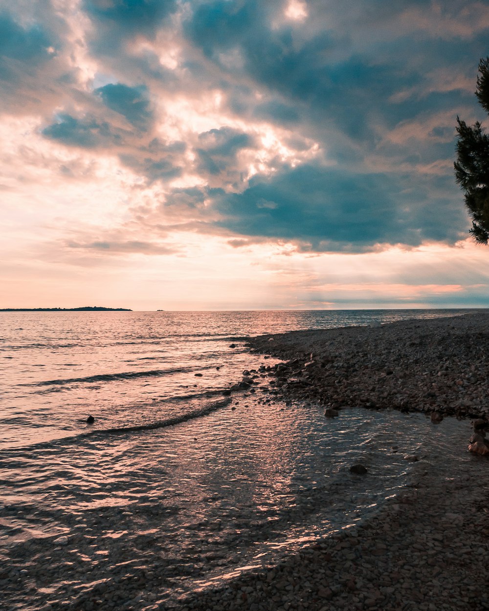 sea waves crashing on shore during sunset