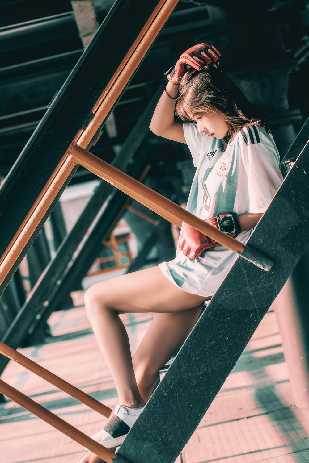 woman in white button up shirt and blue denim shorts sitting on brown wooden window during