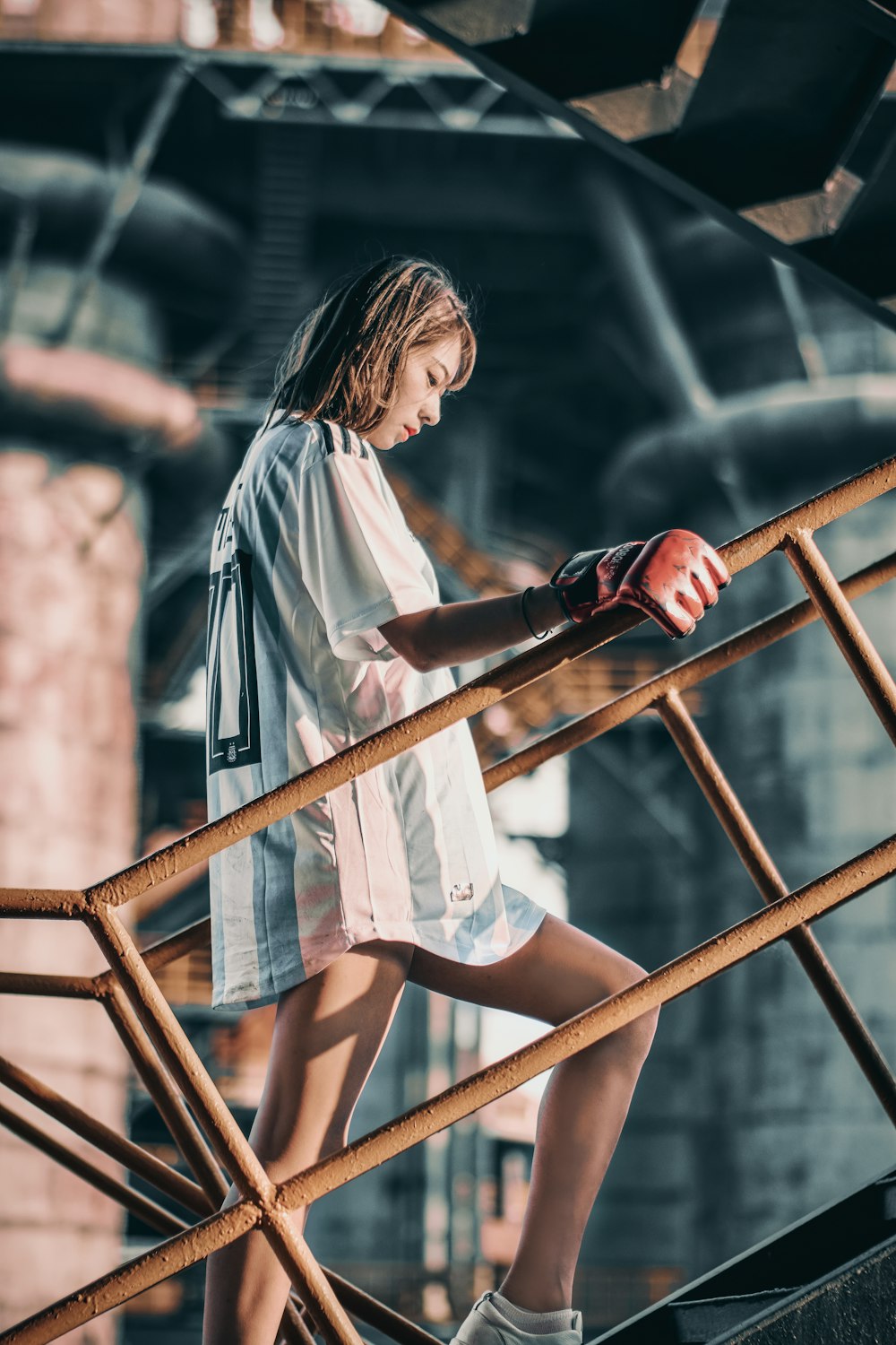 woman in white shirt sitting on brown wooden ladder during daytime