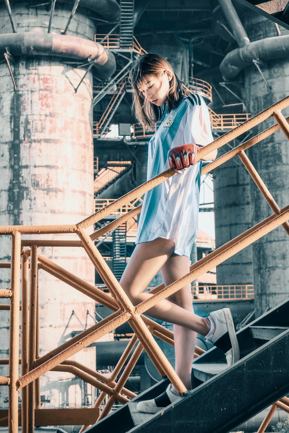 woman in white shirt and blue shorts sitting on brown wooden ladder