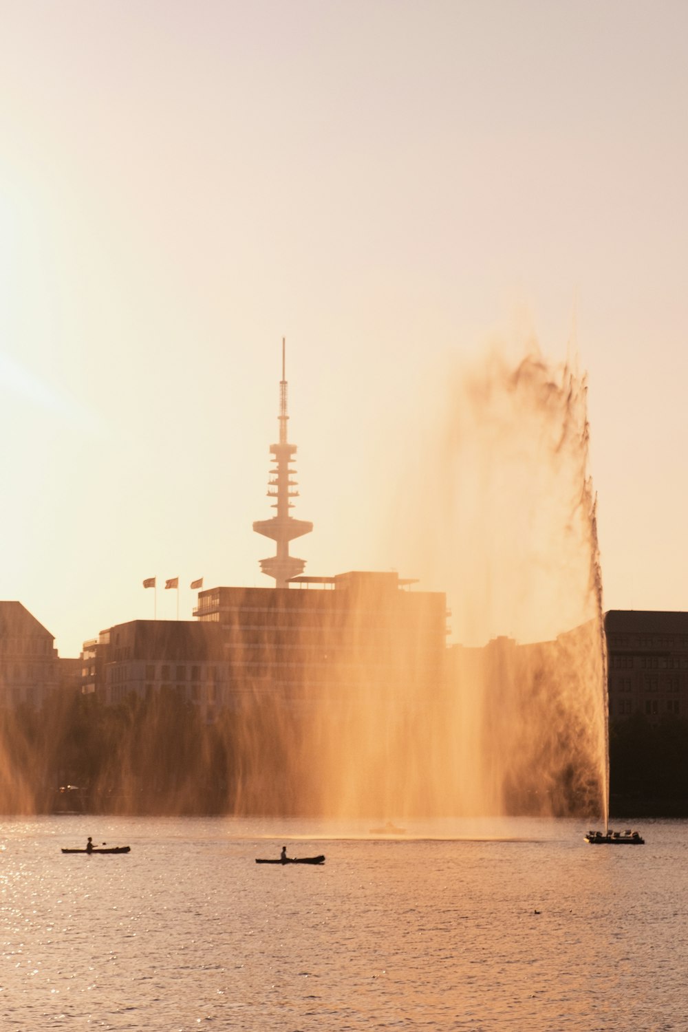 edificio in cemento bianco vicino alla fontana d'acqua durante il giorno