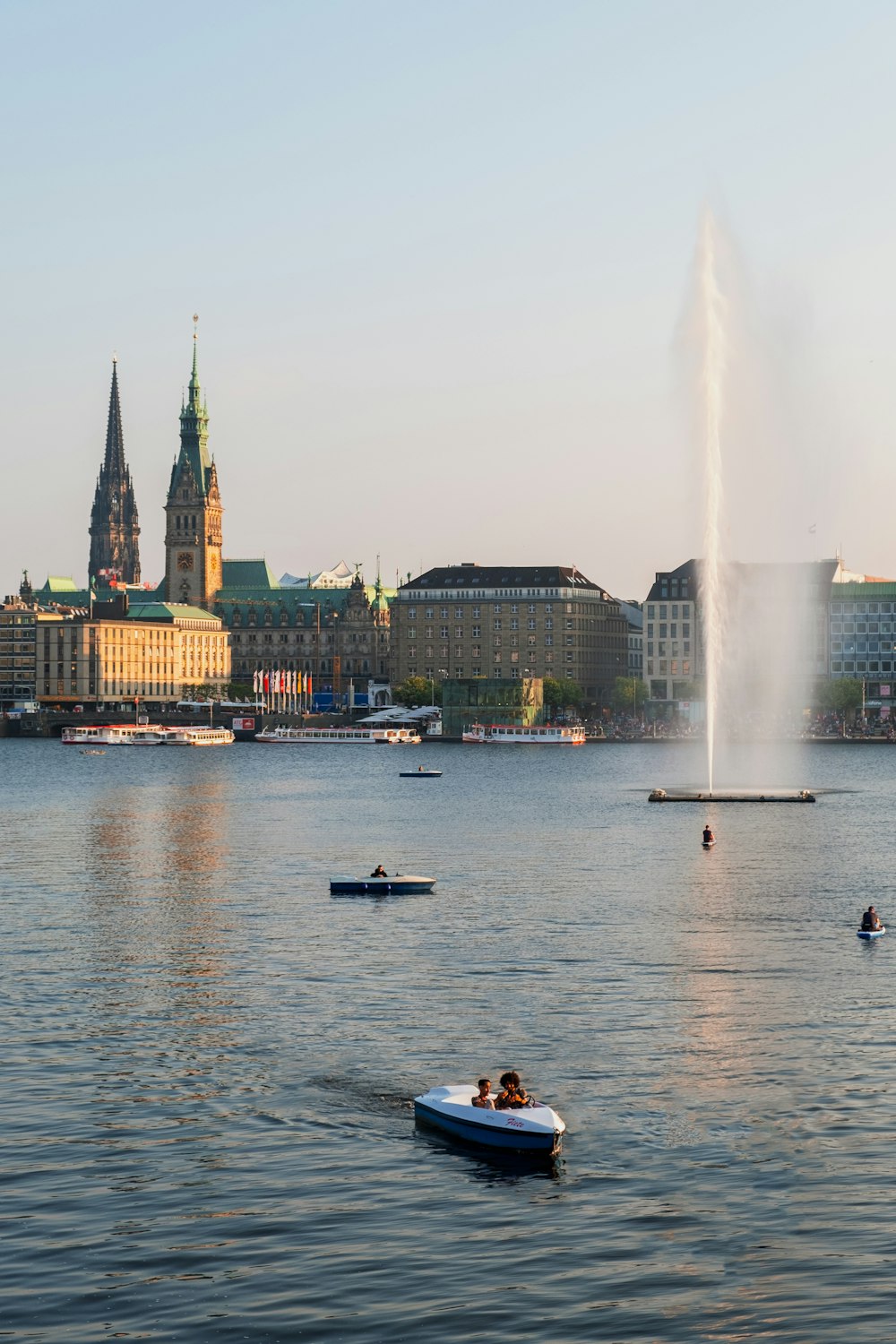 people riding on boat on water near city buildings during daytime