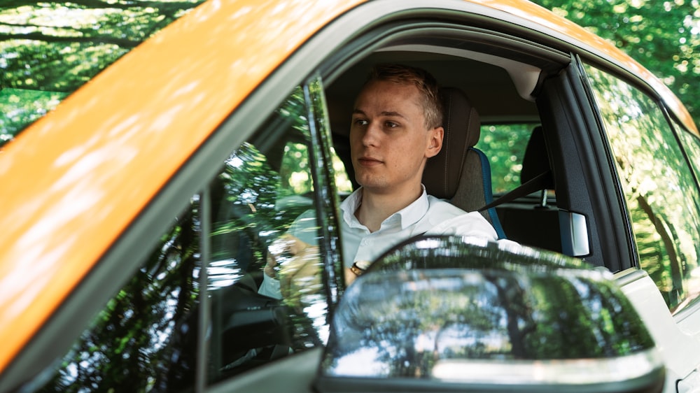 man in white dress shirt and black necktie driving car