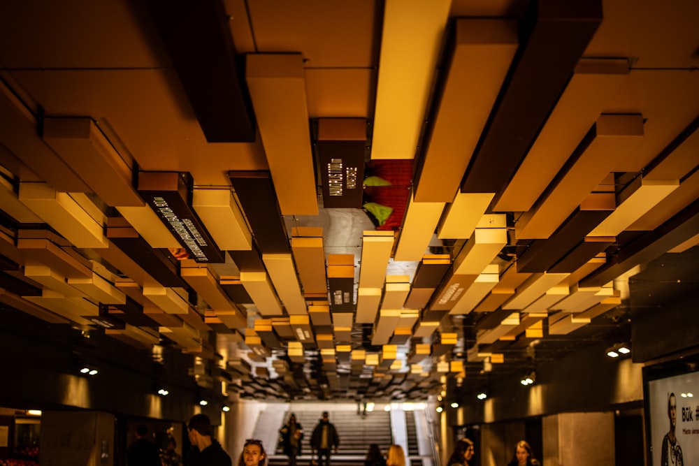 personnes marchant dans le couloir avec des lumières jaunes