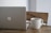 A sleek laptop on a wooden desk with a coffee cup beside it.