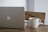 A sleek laptop on a wooden desk with a coffee cup beside it.