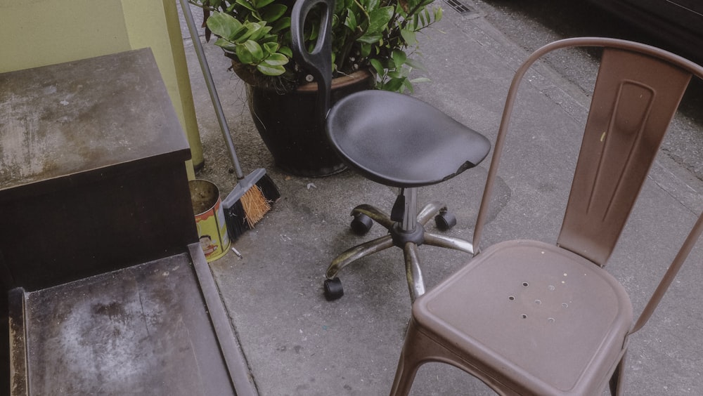 black and gray rolling chair beside green plant