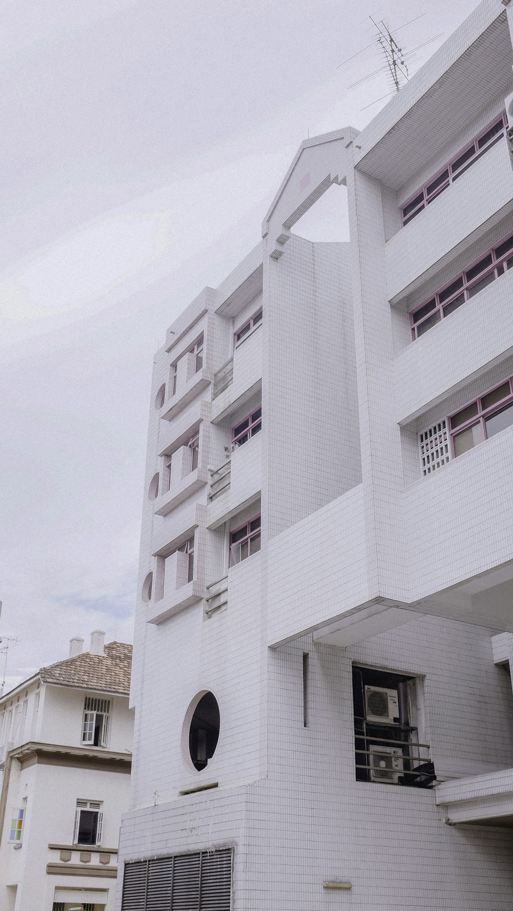 man in black jacket standing beside white concrete building during daytime