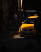 Crisp photo of a clean yellow taxi waiting at a Kuwait city street corner at sunset