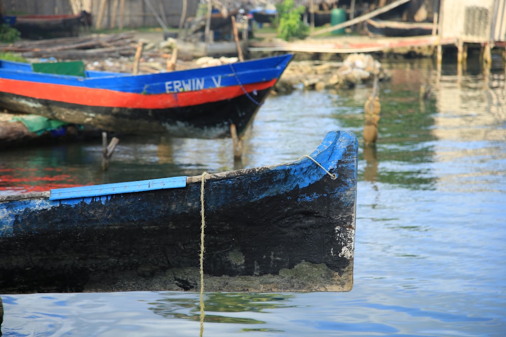 blue and red boat on water during daytime