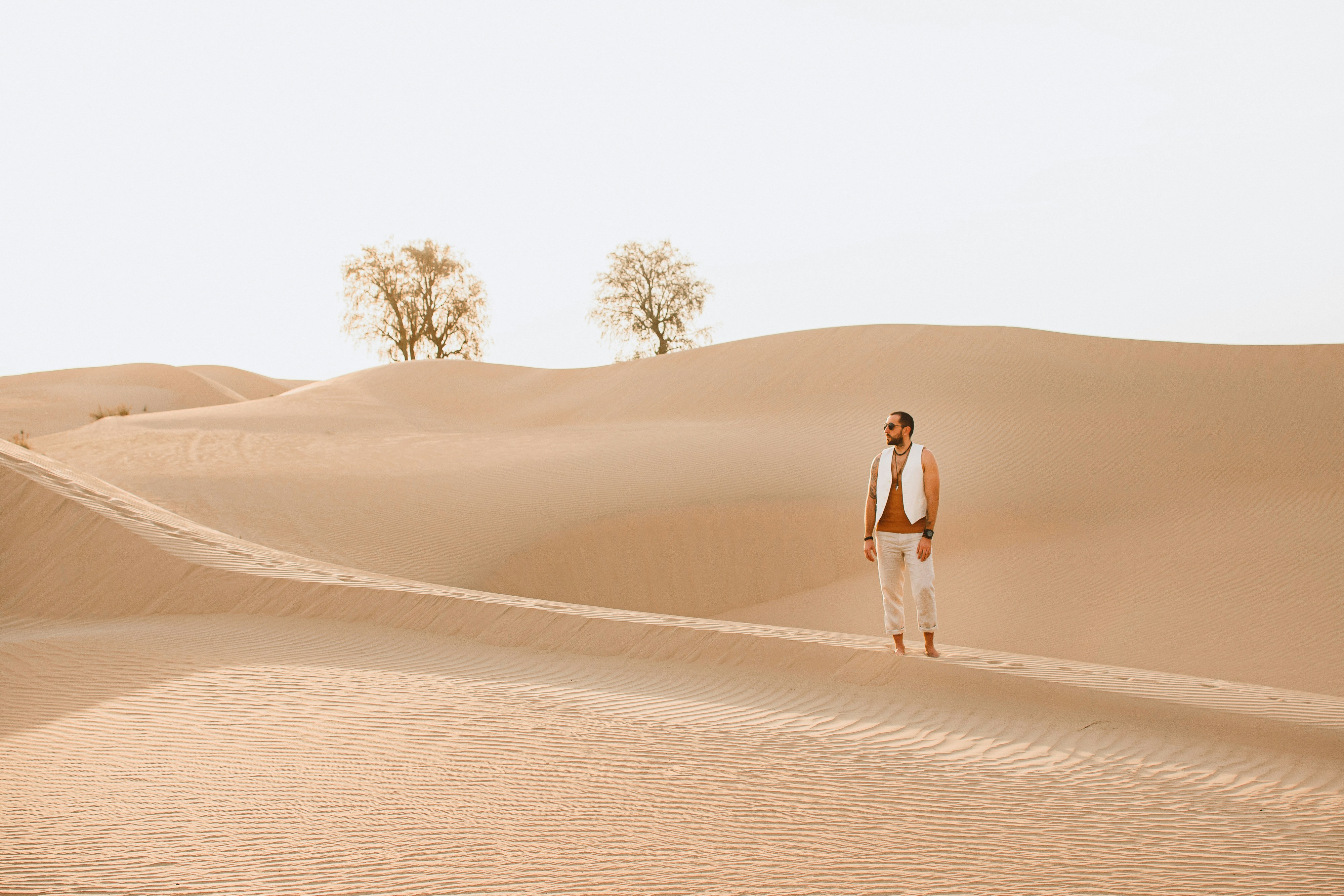 man and woman walking on desert during daytime