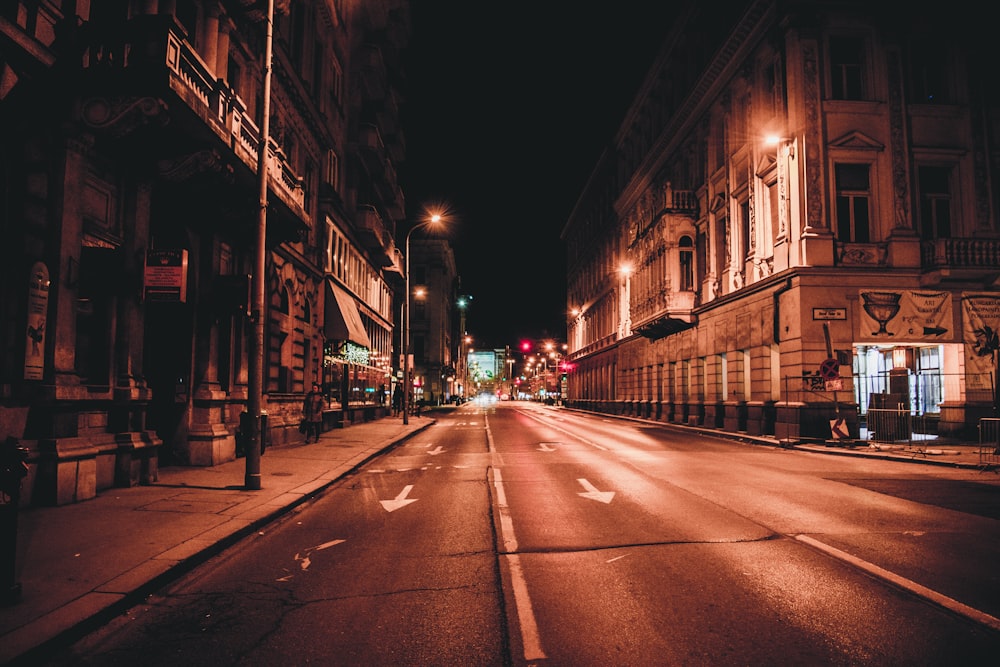 cars on road in between buildings during night time