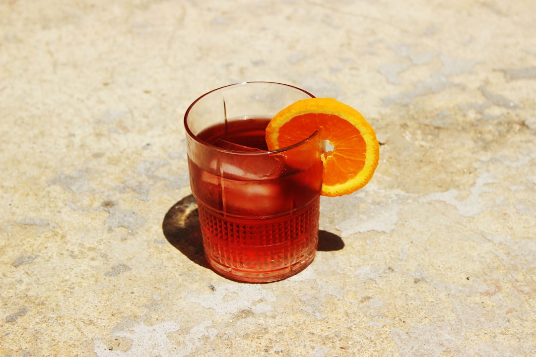 orange juice in clear drinking glass,