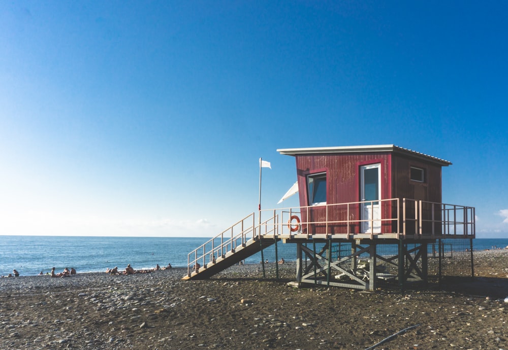 red and white wooden house on beach shore during daytime