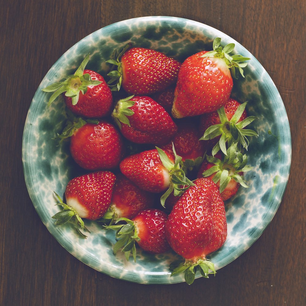 strawberries on blue ceramic bowl