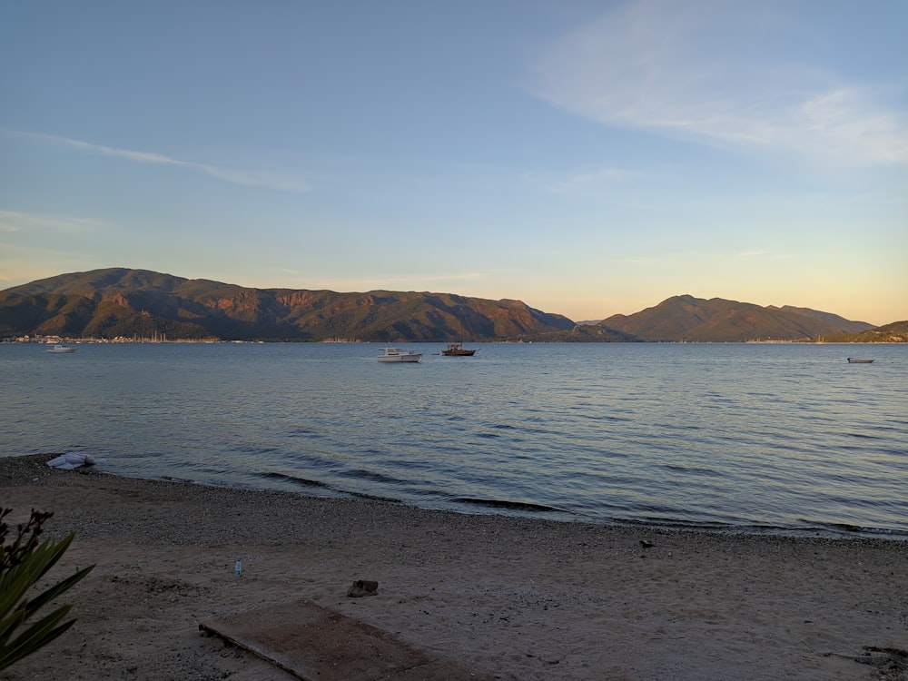 body of water near mountain under blue sky during daytime