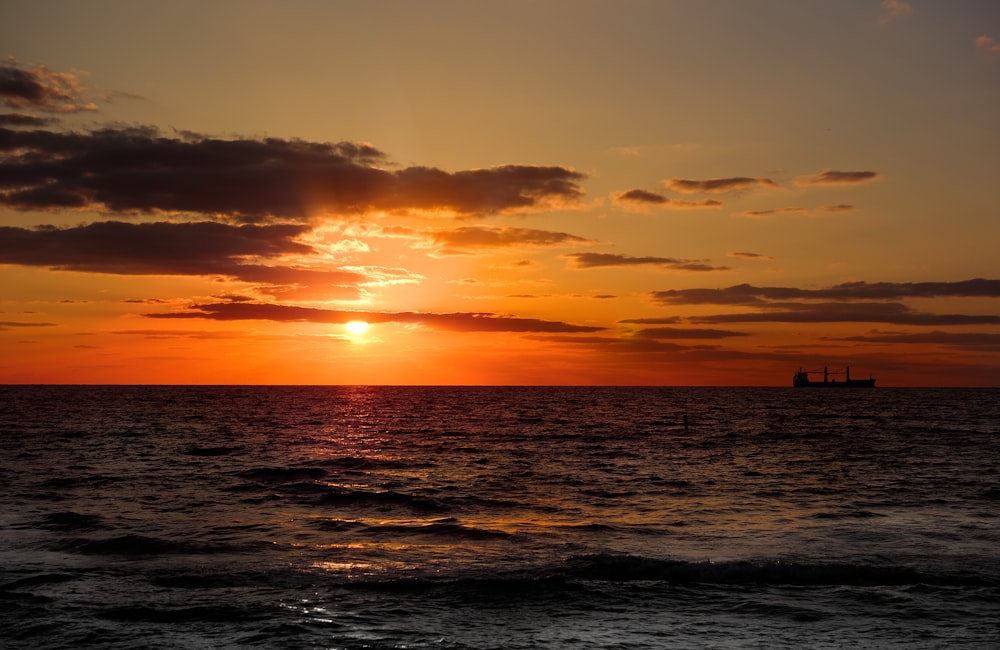 silhouette of person standing on the beach during sunset