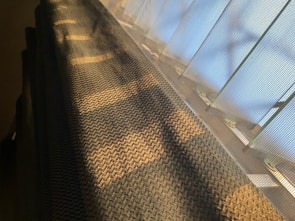 Warm amber light illuminating the delicate weaving pattern created by wovenstrong’s new technology.
