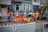 group of men in orange suit standing near building during daytime