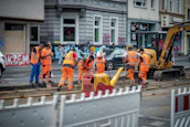 group of men in orange suit standing near building during daytime