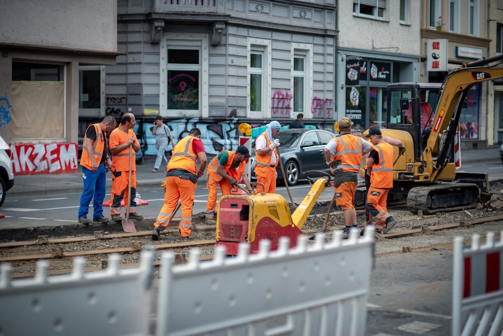 Gruppe von Männern in orangefarbenem Anzug, die tagsüber in der Nähe des Gebäudes stehen