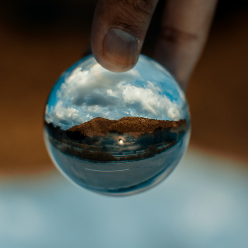 person holding clear glass ball