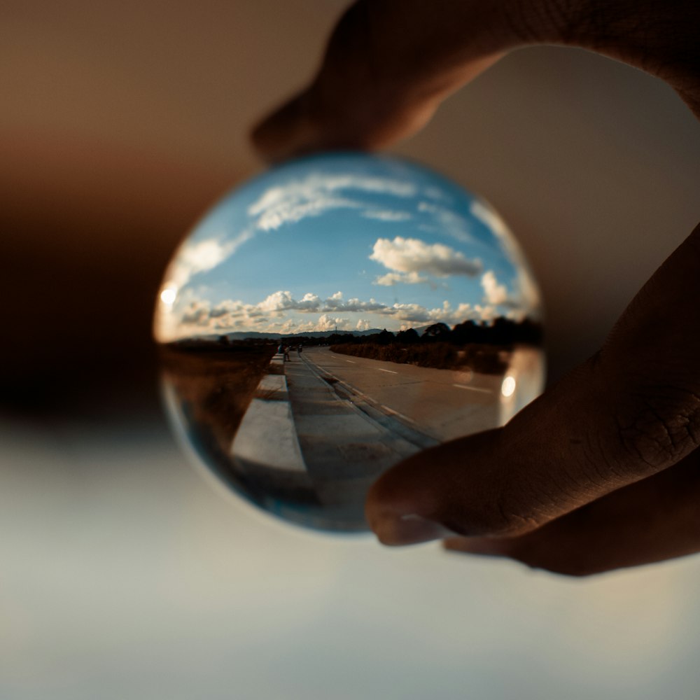 person holding clear glass ball