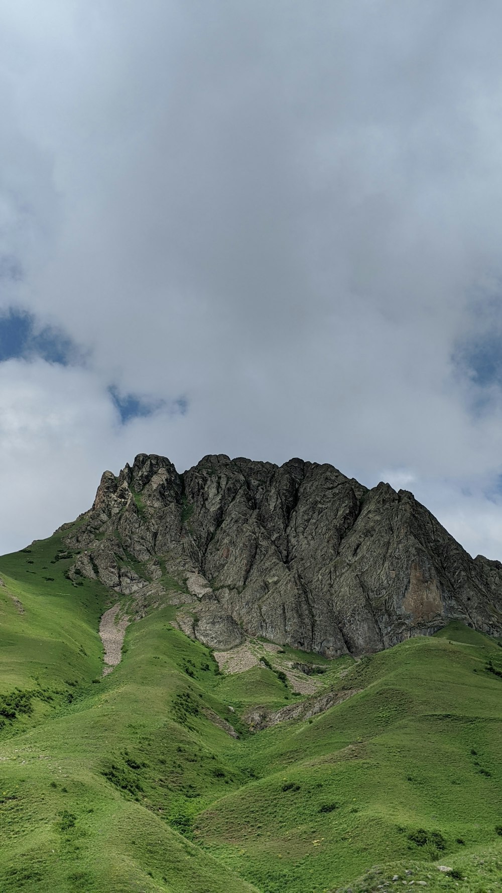 montanha verde e cinza sob nuvens brancas