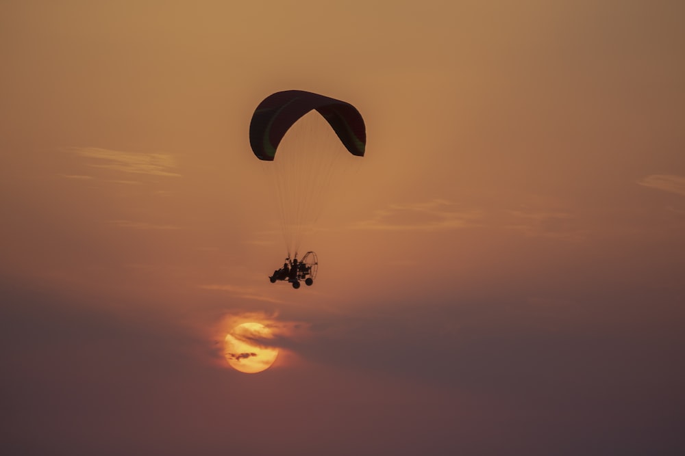 person in parachute during sunset