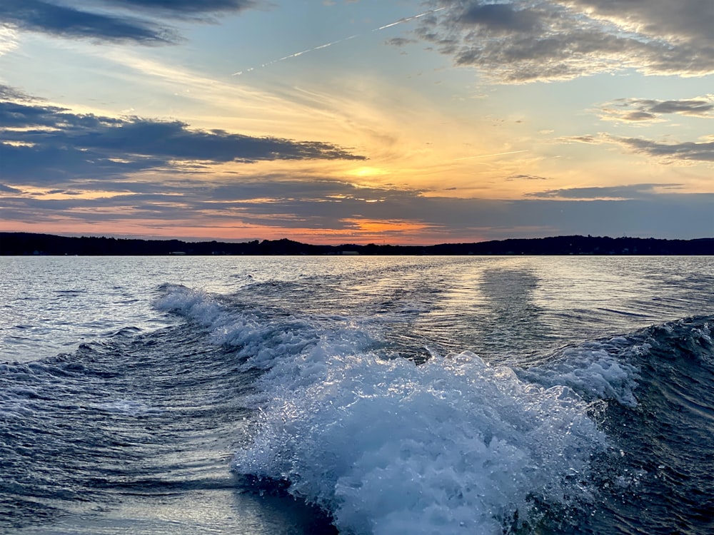 ocean waves crashing on shore during sunset