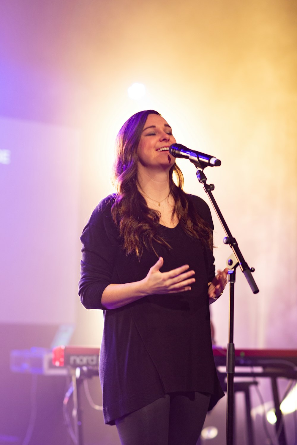 mujer con camisa negra de manga larga cantando