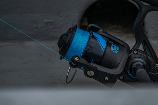 black and blue fishing reel with blue fishing line