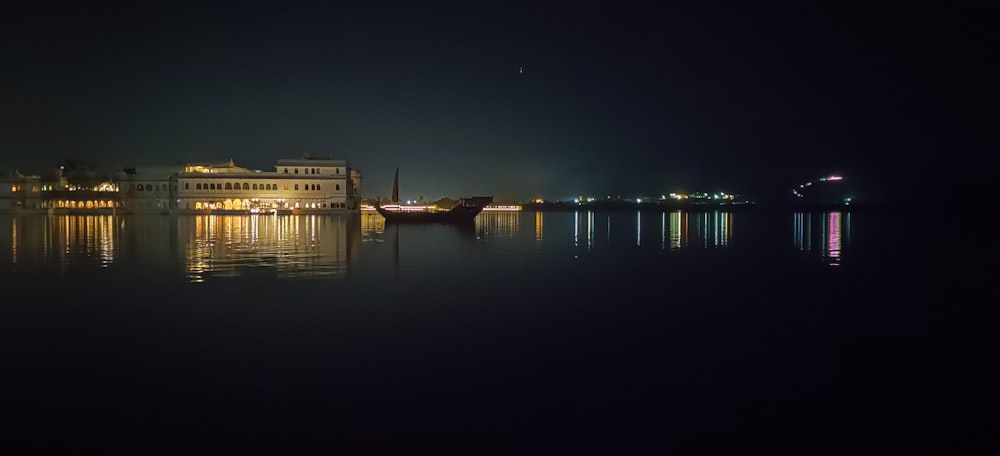 white concrete building near body of water during night time