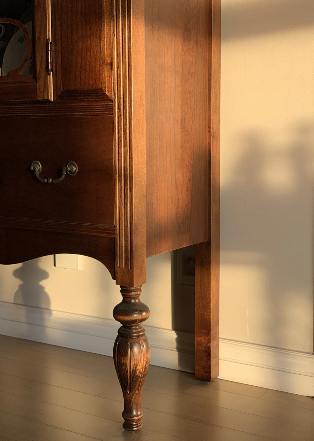Cajón de madera con tirador metálico junto a una pared blanca