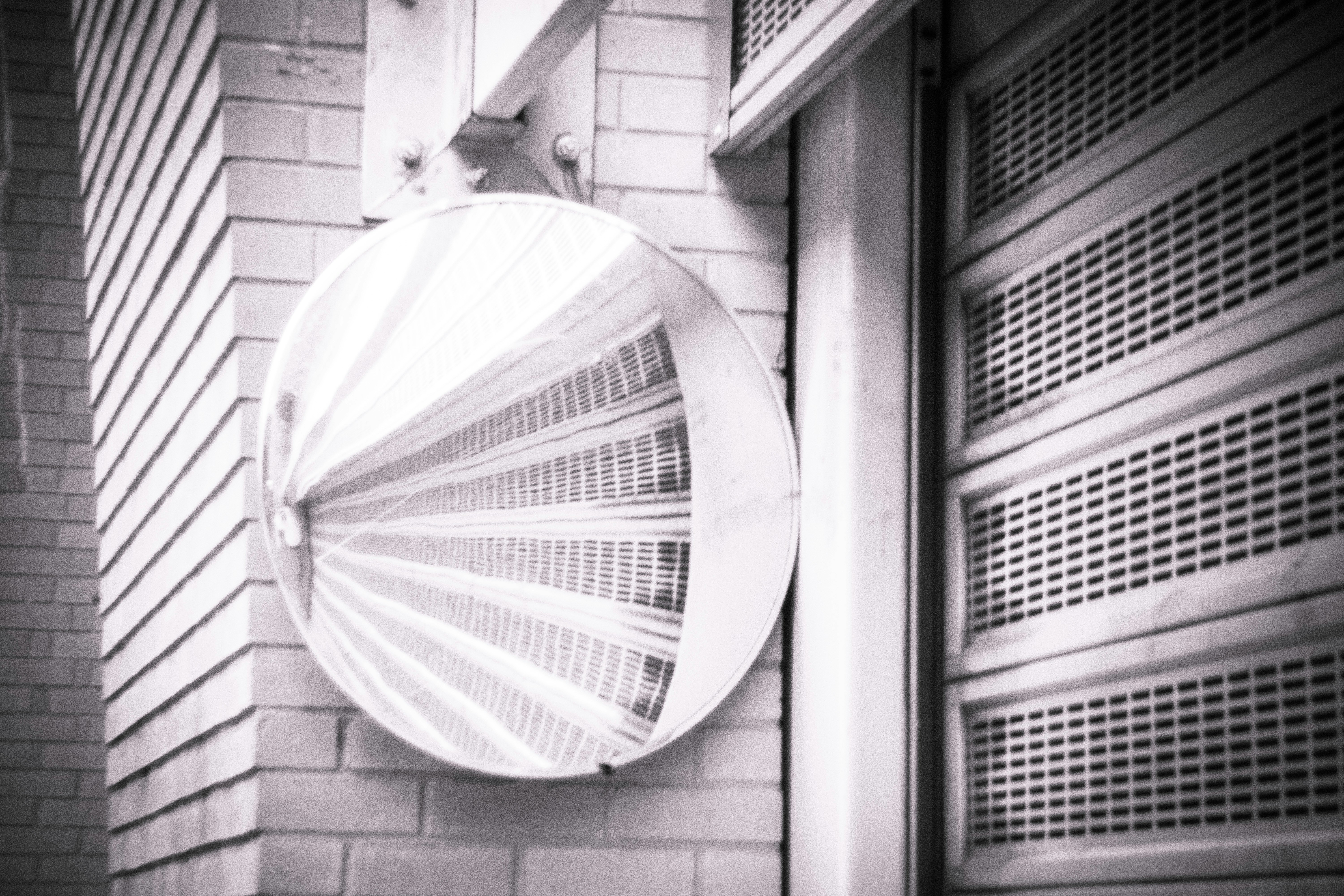 white round outdoor umbrella on gray brick wall