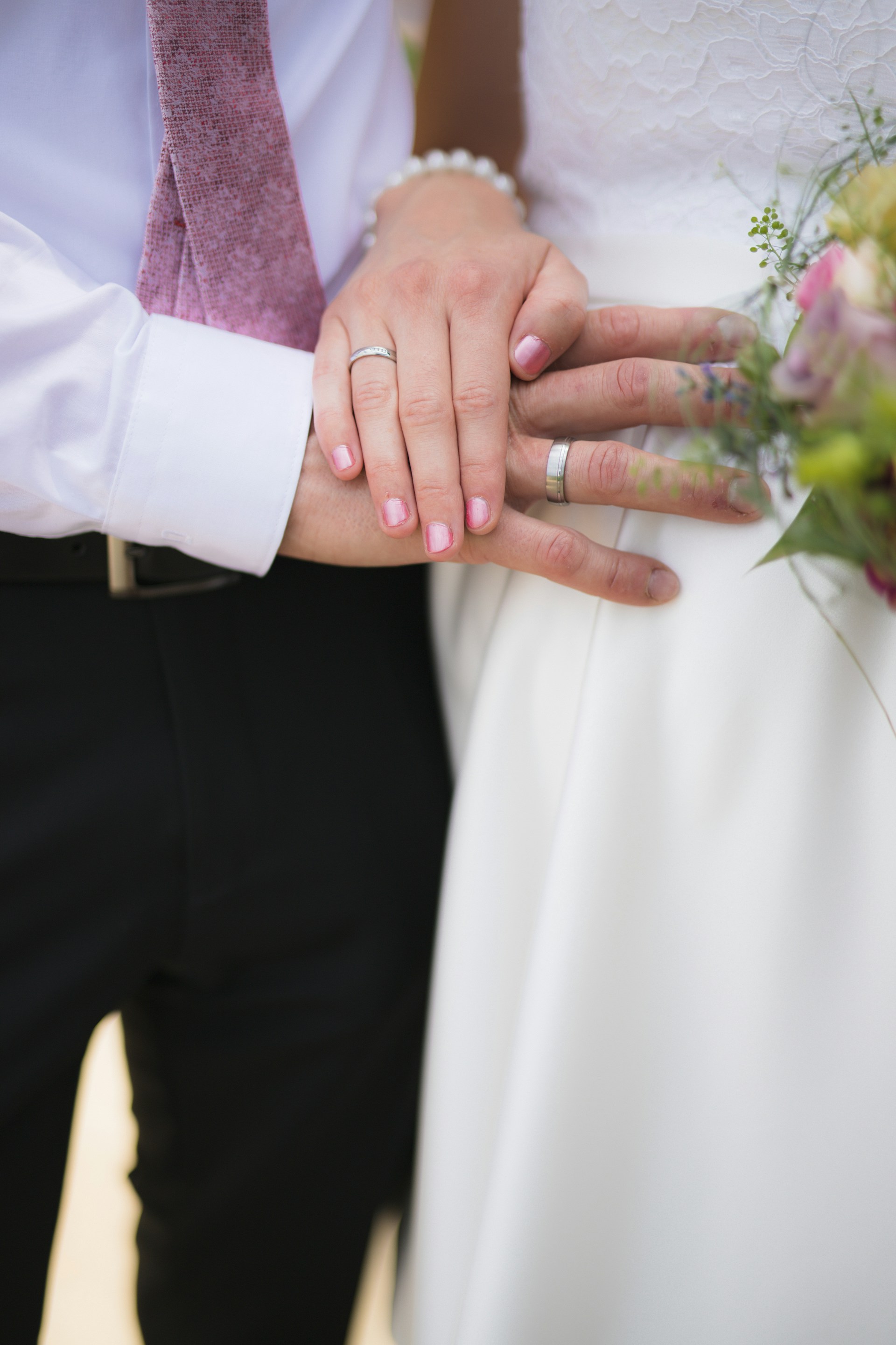 man in black formal suit jacket holding white flower bouquet