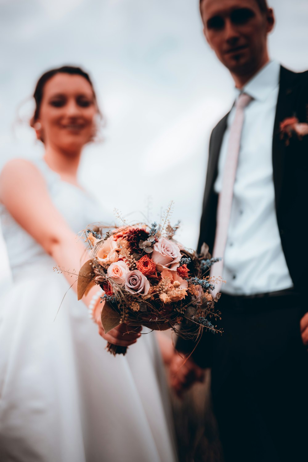 woman in white dress holding bouquet of flowers