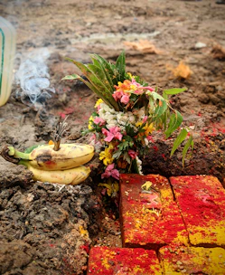 Hands performing a ritual with colorful powders and symbolic objects on a wooden table.